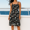 Woman in a floral dress standing on a boat with ocean view