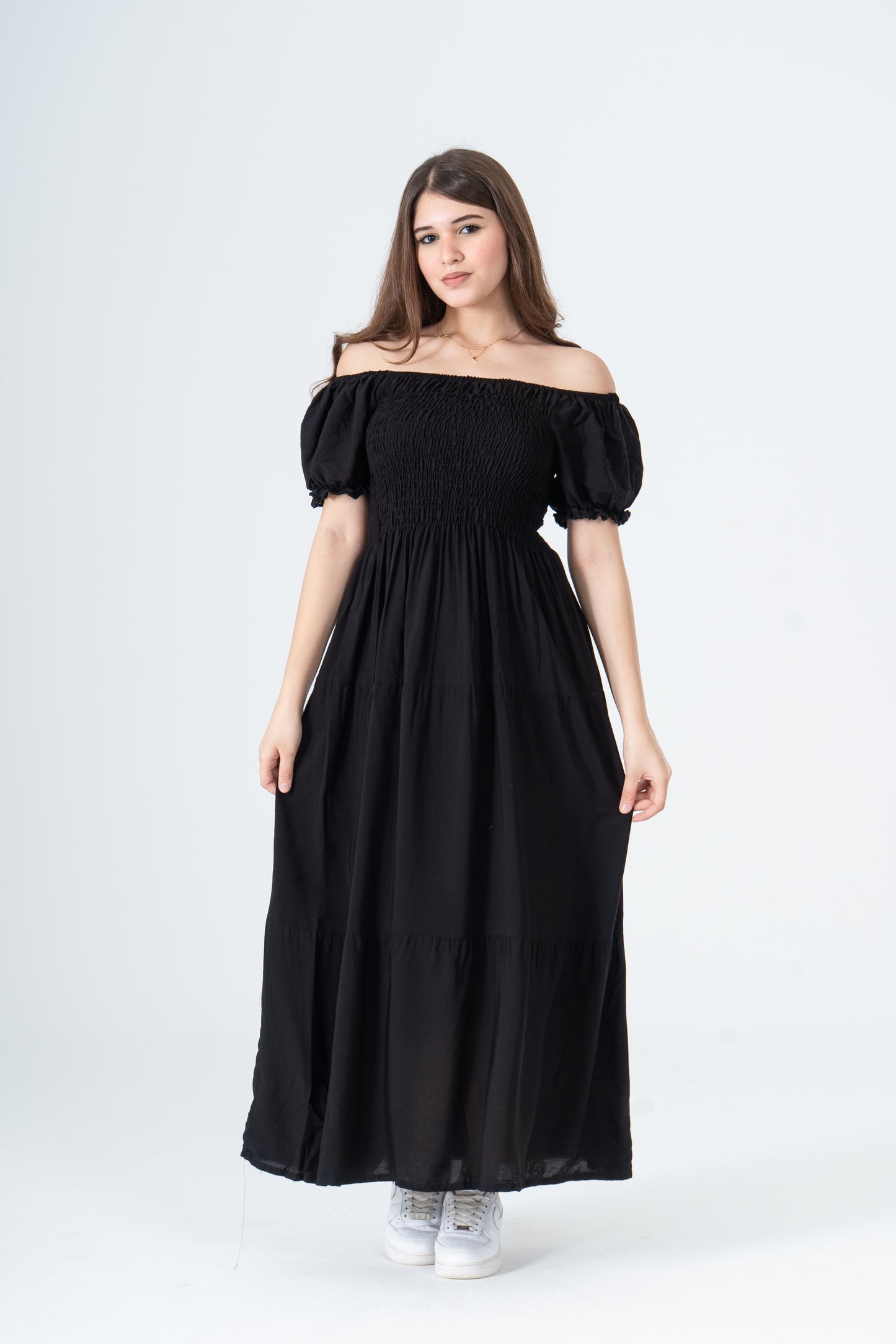 Woman wearing a black off-shoulder dress on a white background