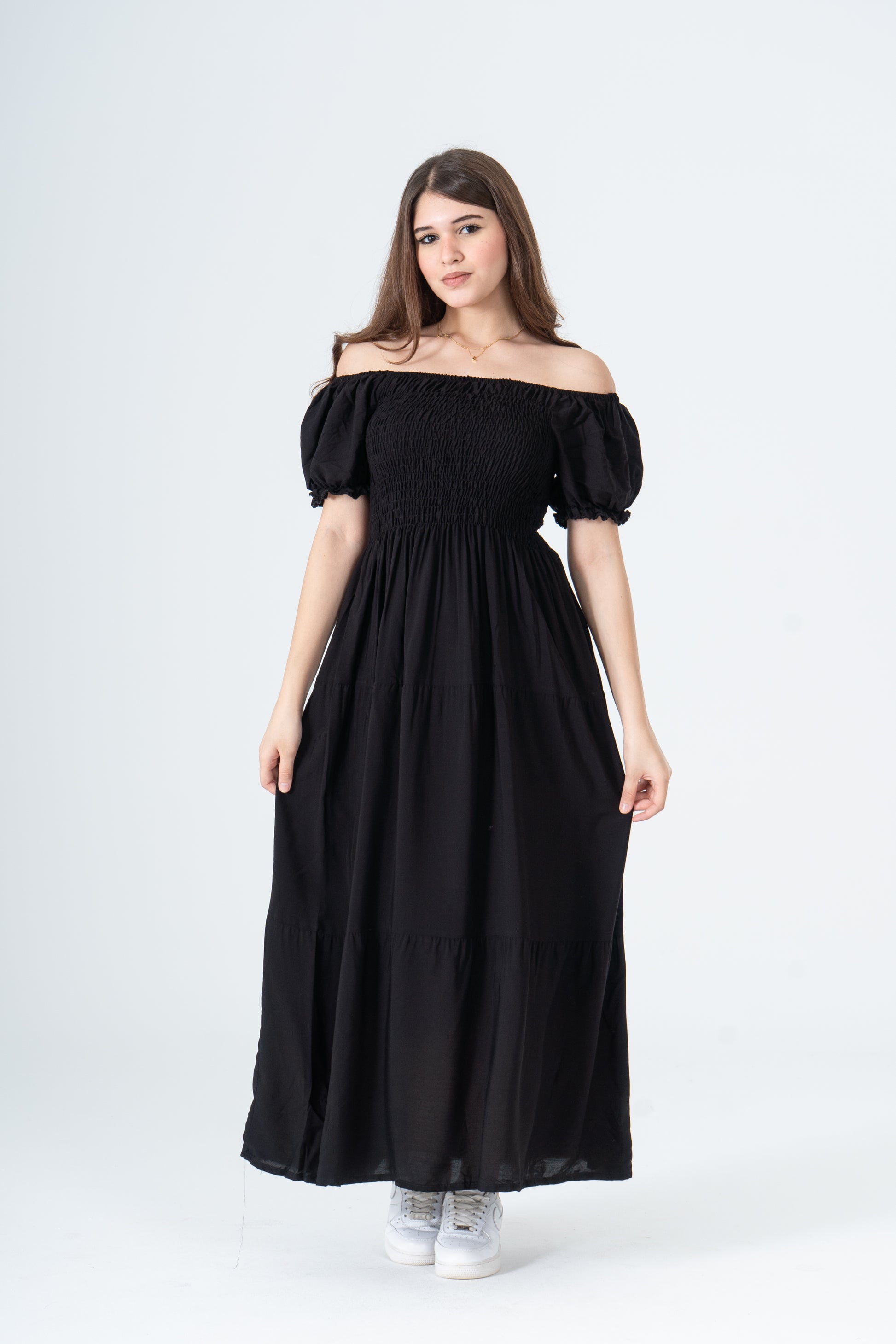 Woman wearing a black off-shoulder dress on a white background